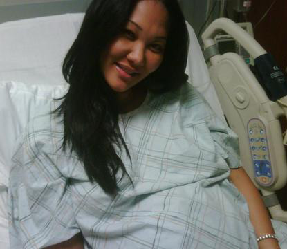 Kimora poses it up from the hospital bed